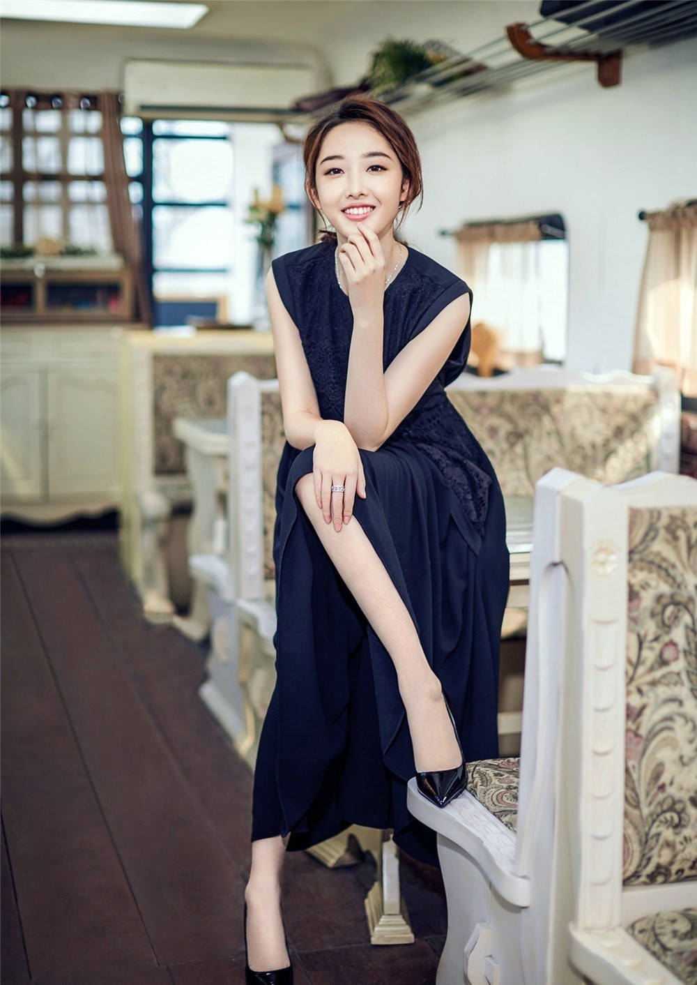 蒋梦婕坐于石阶展露俏皮神情，灵动眼神中闪烁着春日朝气