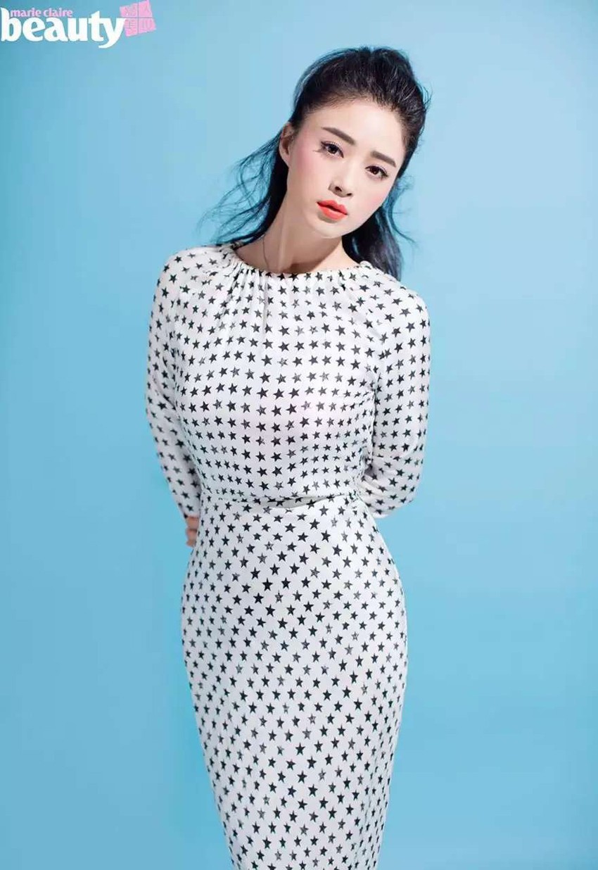 蒋欣身穿粉色旗袍手持团扇，坐于镜前嫣然一笑，尽显东方美人温婉气质