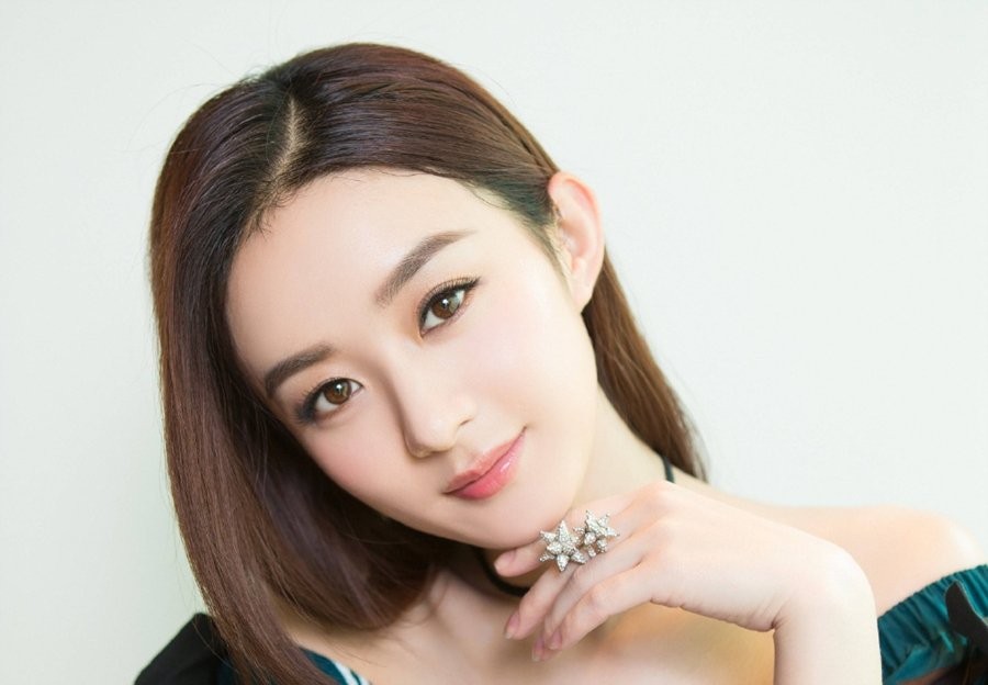 赵丽颖俏皮地倚靠，身穿蕾丝装饰上衣，眼神灵动略带俏皮，展现甜美之外的灵动与个性。