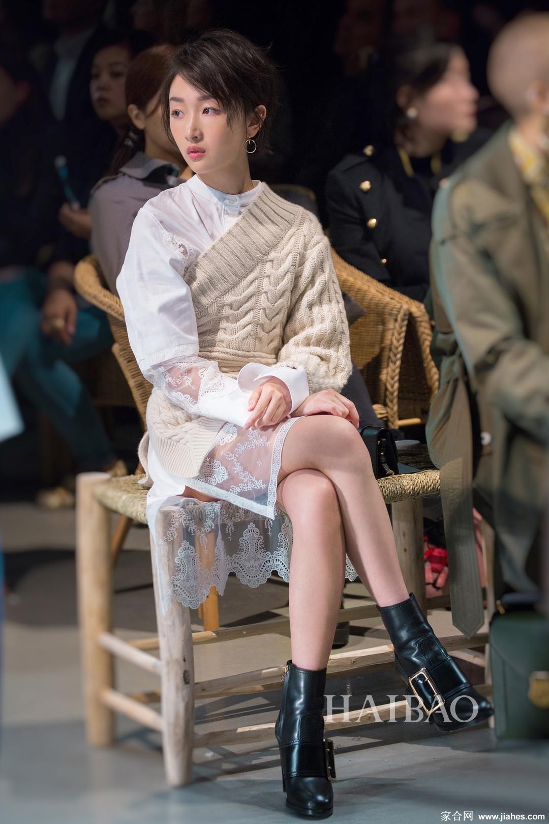 后台瞬间，周冬雨整理妆容，专注神情与黑色挂脖裙的时尚感相得益彰