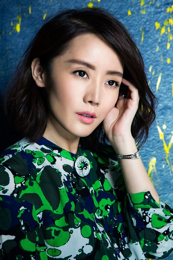 车永莉身穿红色时装倚靠而立，展现自信摩登的强烈气场