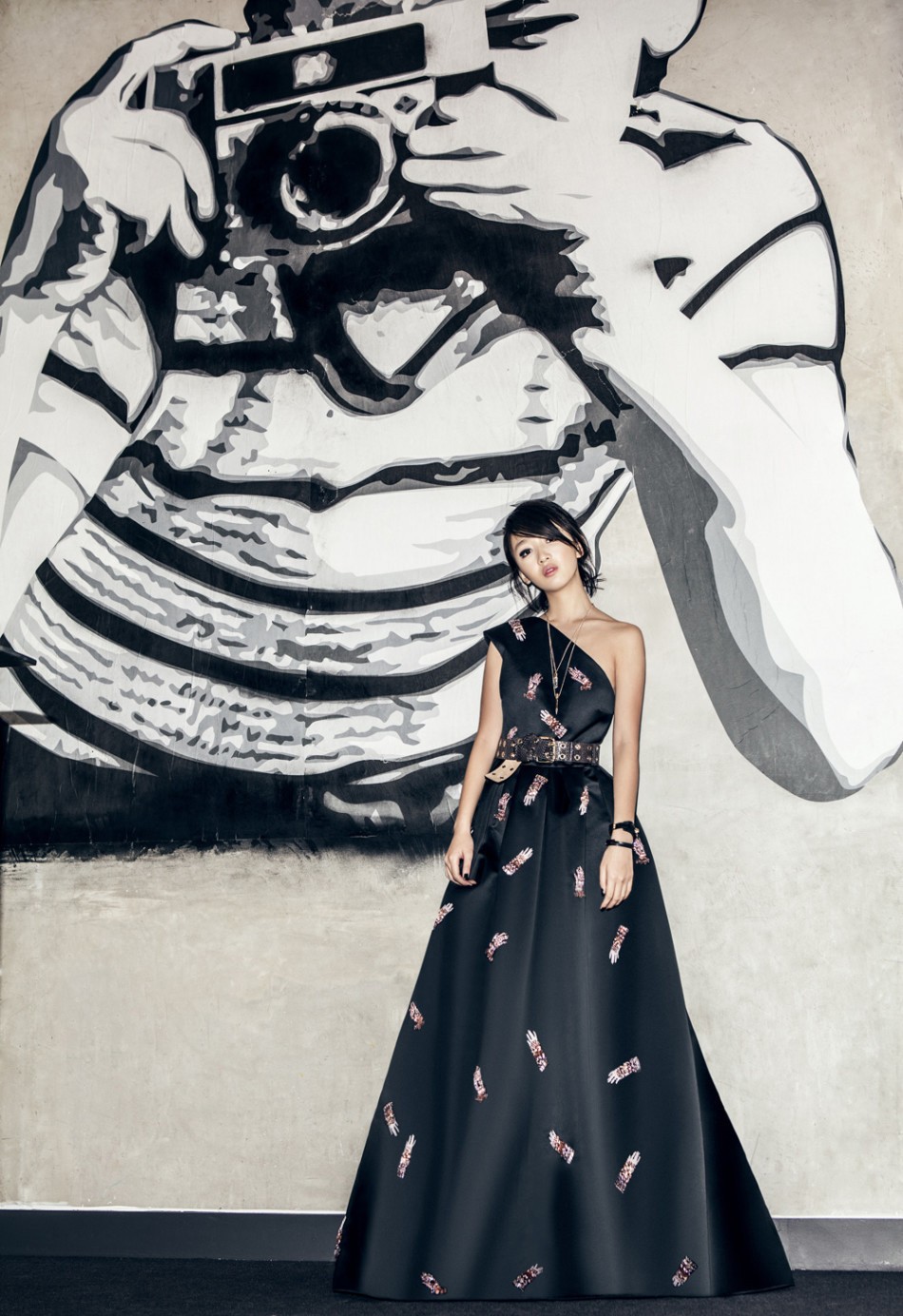 周冬雨倚靠墙面姿态放松，皮衣与烟熏妆勾勒出慵懒而危险的摇滚魅力