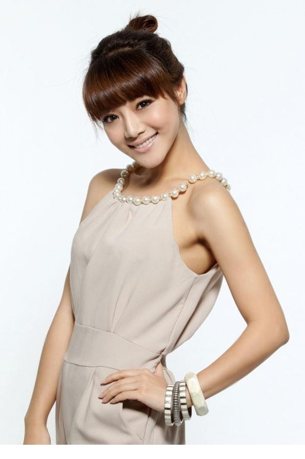 邓家佳俏皮地托腮微笑，光影洒落肩头，尽显灵动少女感与轻熟风韵的精妙融合