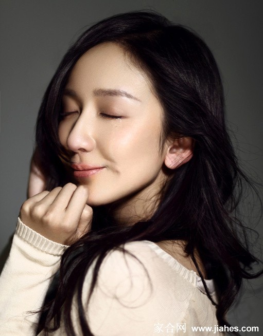 娄艺潇身着米白色针织长裙侧身凝望，窗边光影洒落肩头，仿若一幅静谧的古典油画