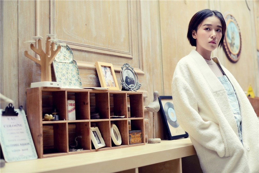 阚清子坐于地上粉色裙摆如花朵铺展手捧雏菊花束神情恬静安然