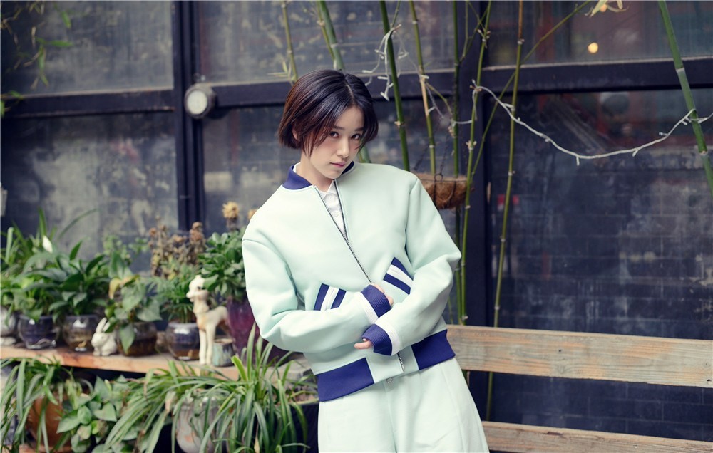 阚清子身着粉色长裙侧身而立手持花束眼神温柔眺望远方