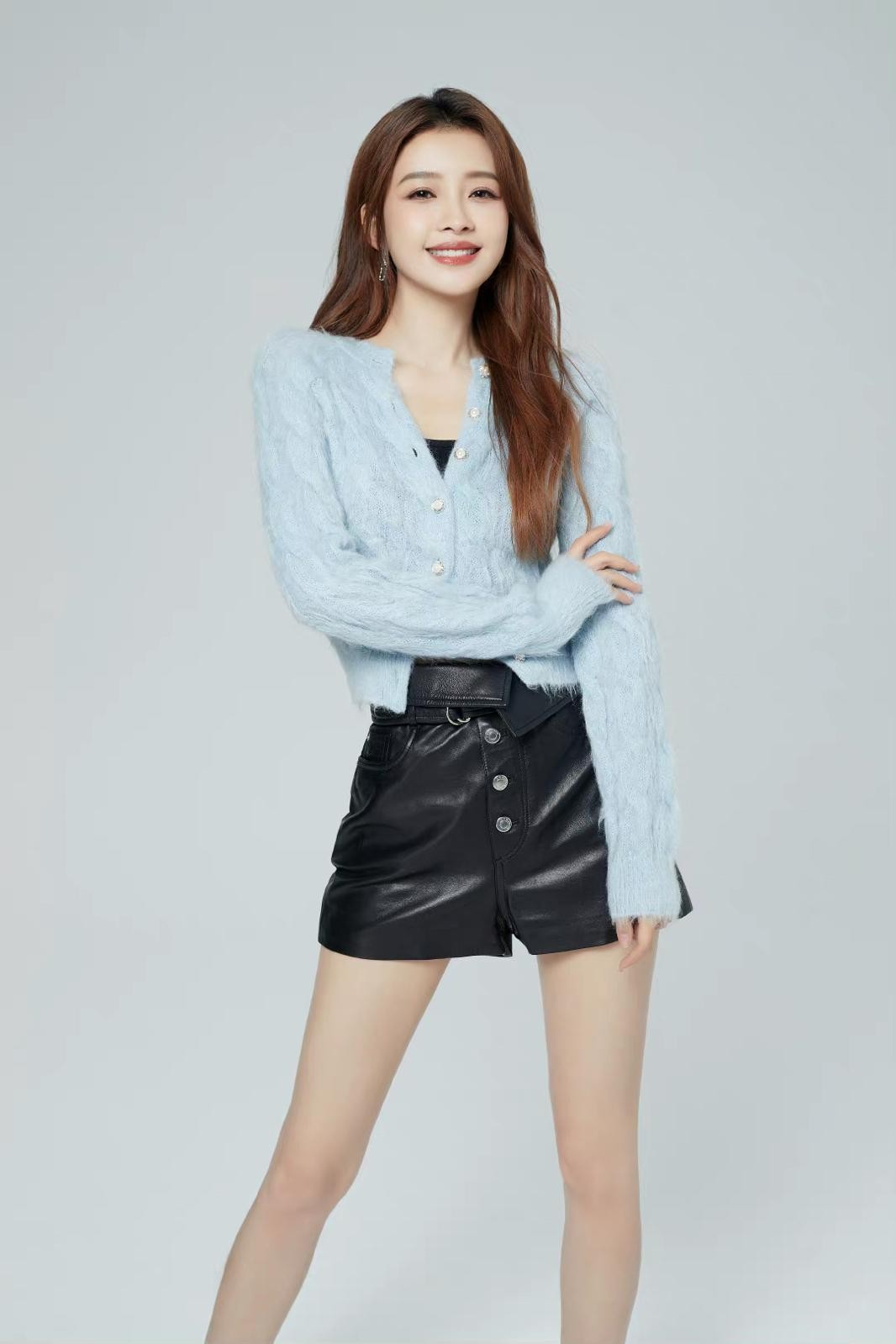 孙怡身穿复古拼色棒球服与牛仔短裙，站在街角回眸甜笑，尽显清新活力