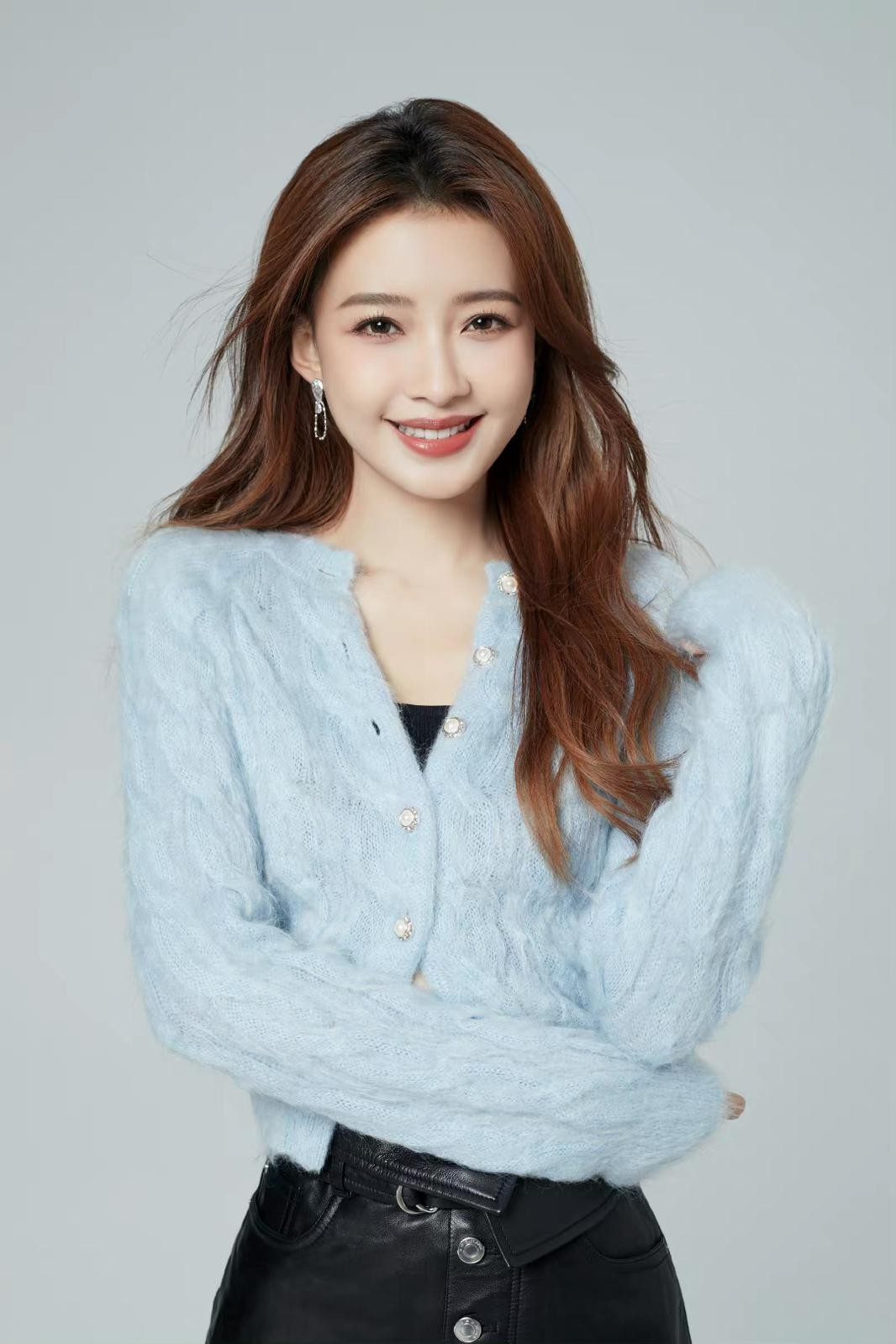 孙怡倚靠栏杆，牛仔短裙下双腿笔直修长，尽显慵懒随性的街头时尚感