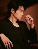 魏大勋身着经典黑色西装侧身而立，灯光勾勒出其挺拔修长的身形与西装精致的剪裁轮廓