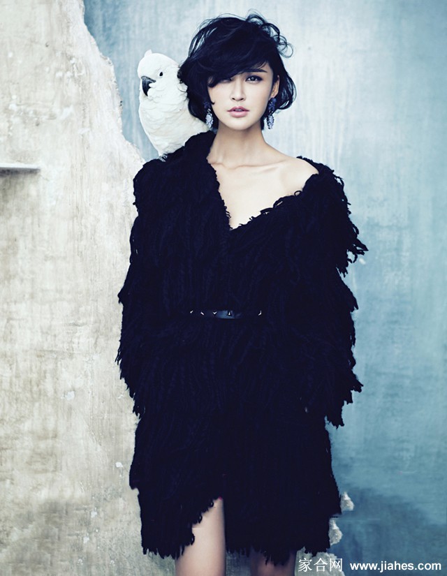 张歆艺着简约深V长裙立于光影交错间，轮廓分明展现静谧强大气场