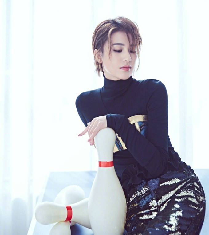 黄圣依身穿印花风衣，慵懒漫步于金黄向日葵花海，尽显秋日浪漫气息