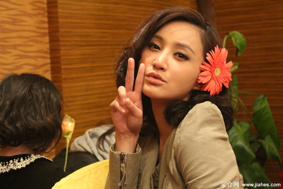 置身于简约背景前，她姿态放松，自然流露的恬淡气质格外迷人