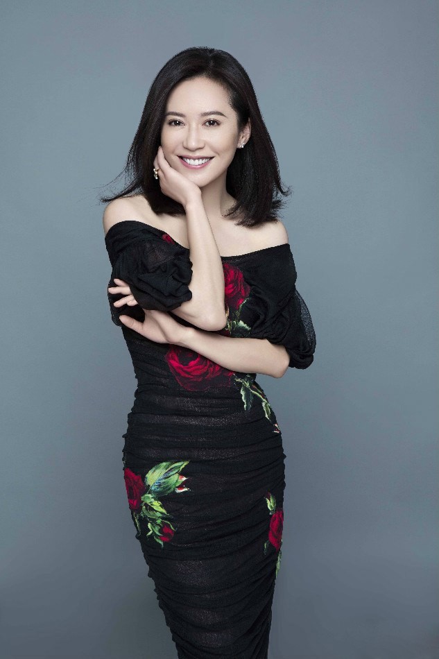 俞飞鸿身着简约针织长裙侧首浅笑，午后阳光为她周身镀上一层温柔光晕