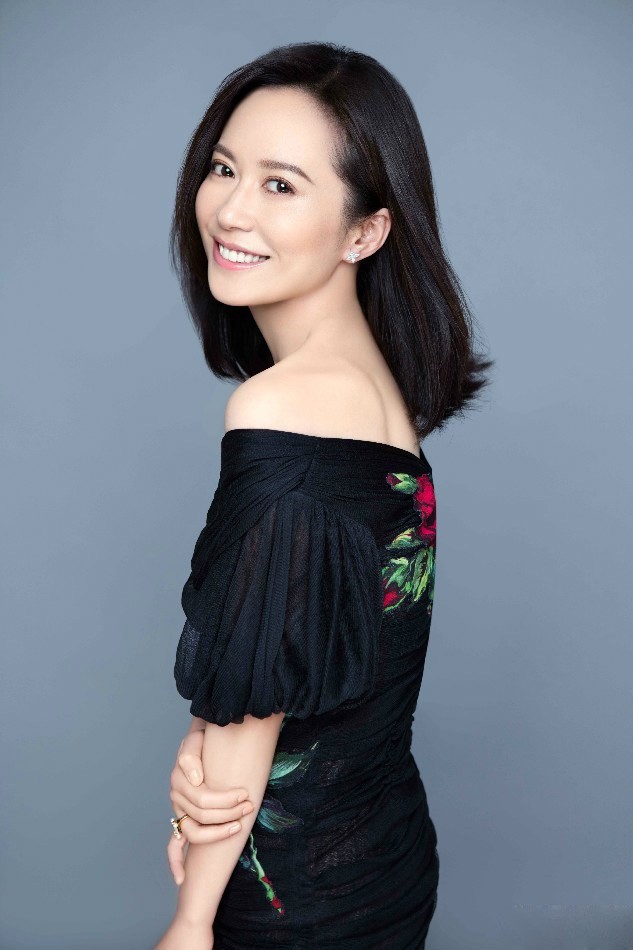 俞飞鸿黑衣造型目光沉静望向远方，都市光影交错映衬其独立自信姿态