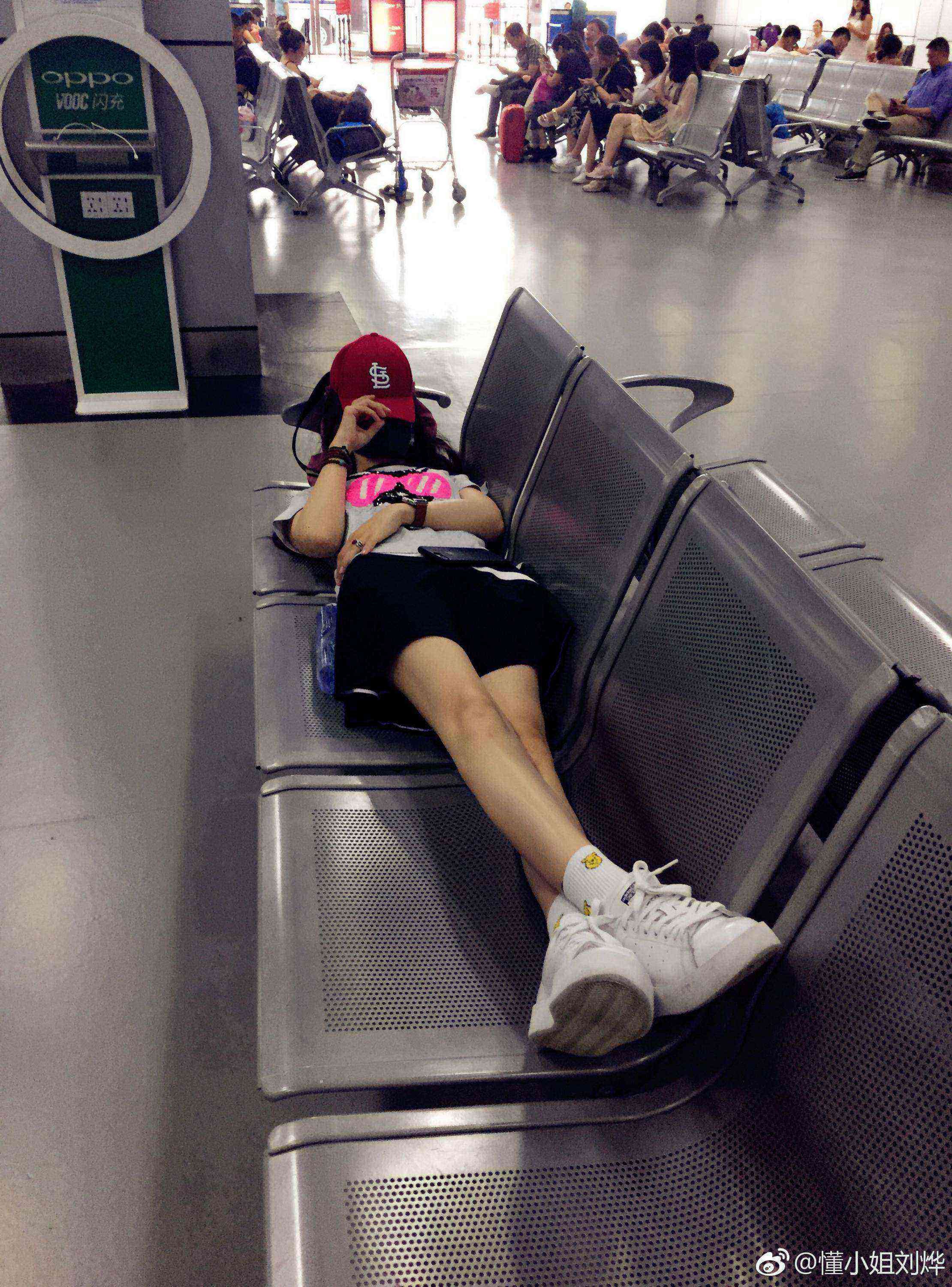 刘烨漫步于林荫小道，回眸浅笑，风衣下摆随风轻扬，腿部线条在丝袜衬托下更显纤长