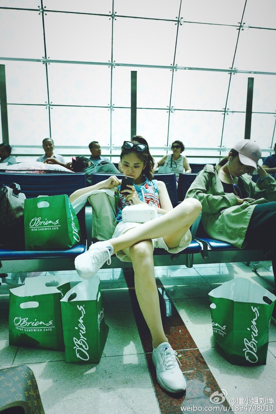 刘烨侧身立于复古墙面前，光影勾勒出她优雅的侧颜与全身轮廓，丝袜美腿成为画面焦点