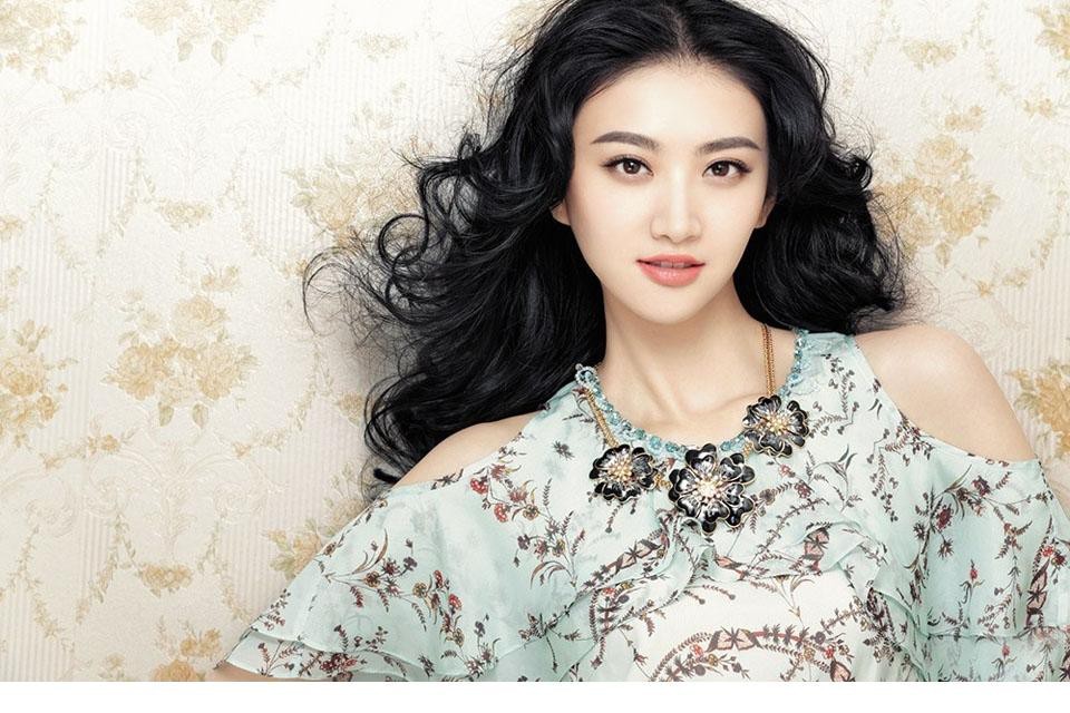 景甜侧身回眸眼神灵动，层叠裙摆随风轻扬宛若绽放的花朵