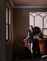 杨幂背影示人，曳地羽毛裙摆铺展于地面，展现礼服背部精美设计与整体流畅廓形