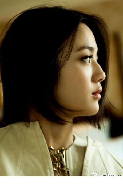 汤唯侧身托腮凝望窗外，眼神清澈似在捕捉某个有趣的念头