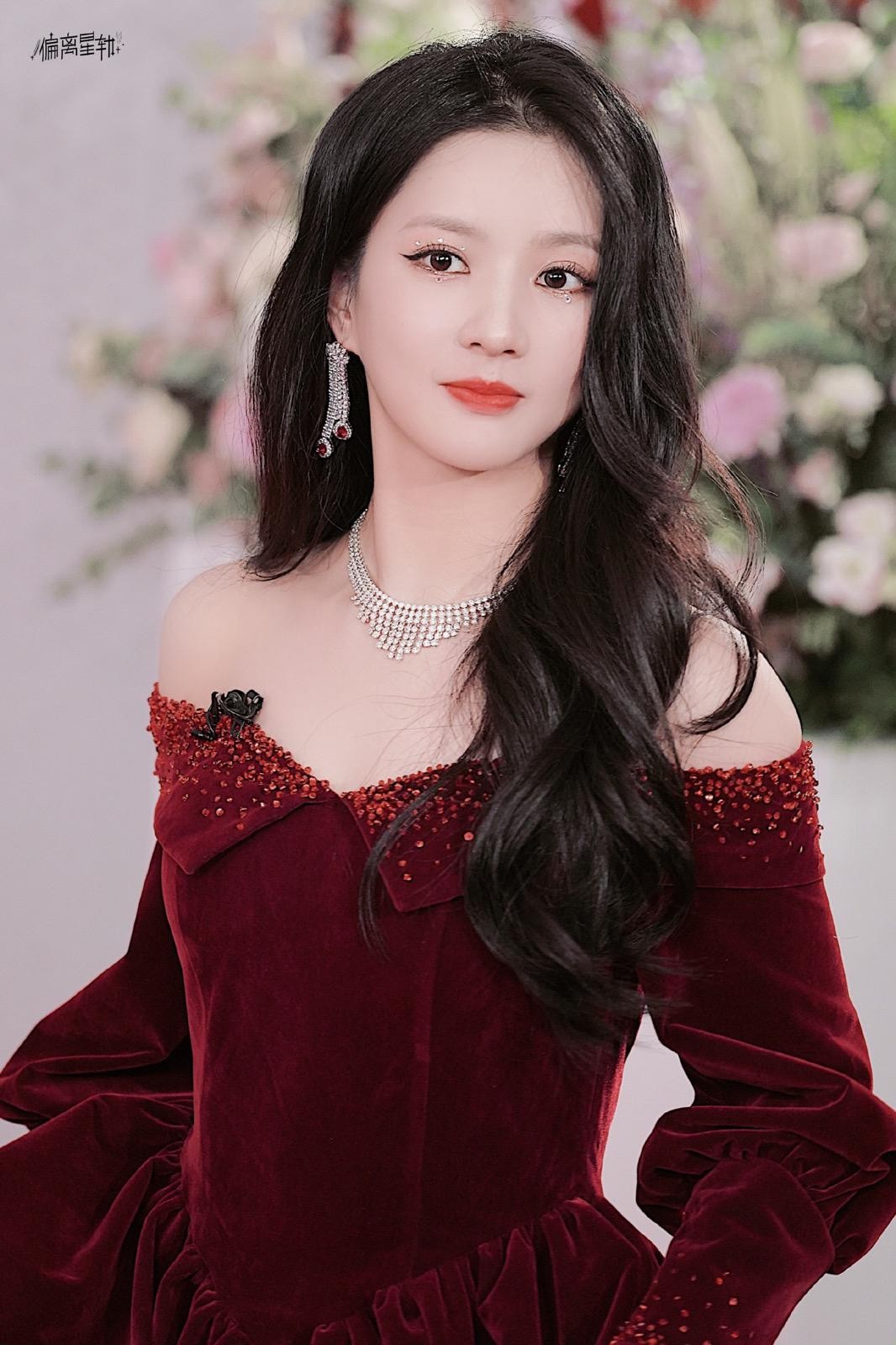 刘些宁手持复古折扇半遮面，眼神中带着一丝神秘与戏谑，犹如古典故事中走出的佳人