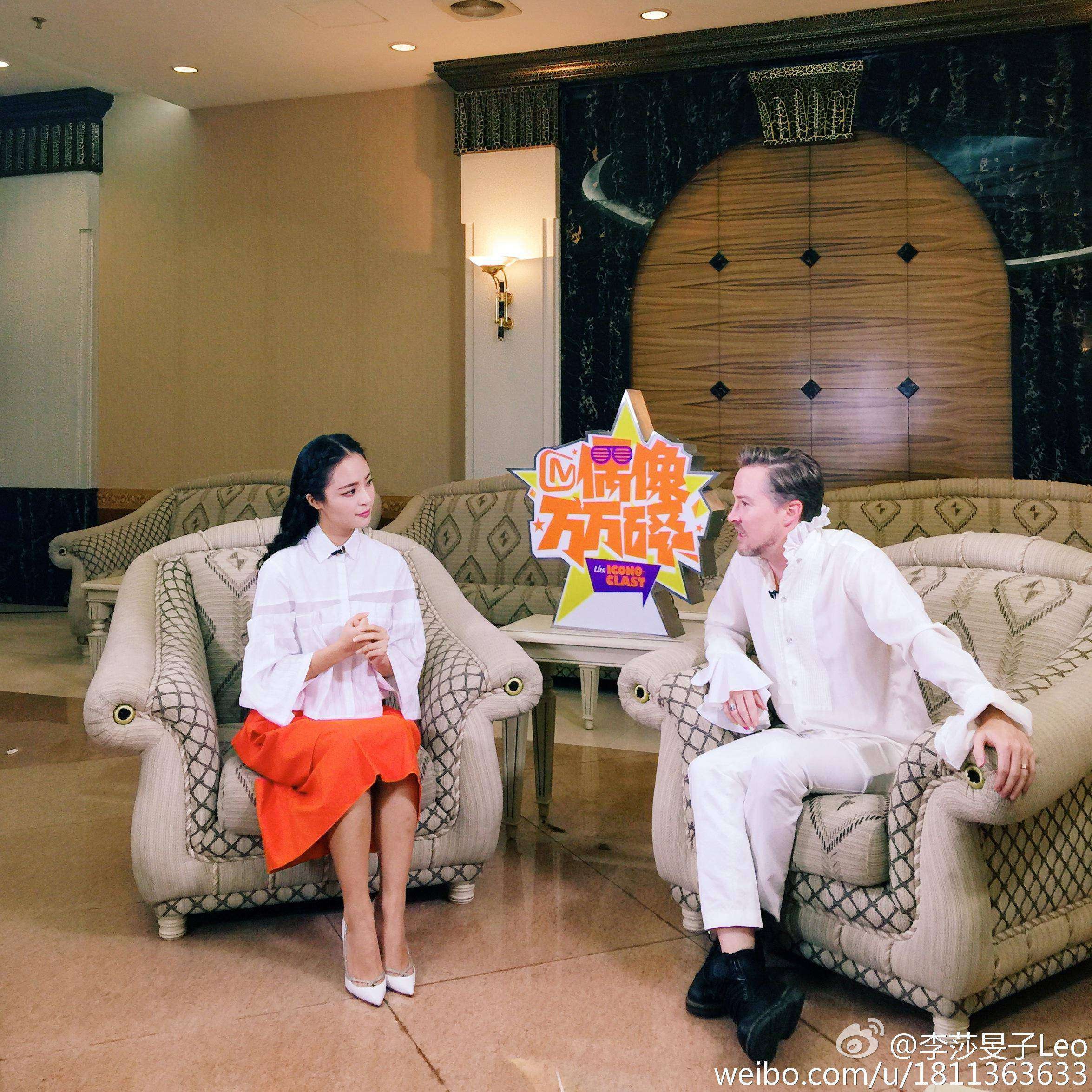 李莎旻子坐在高脚凳上，短裙设计凸显修长匀称的腿部